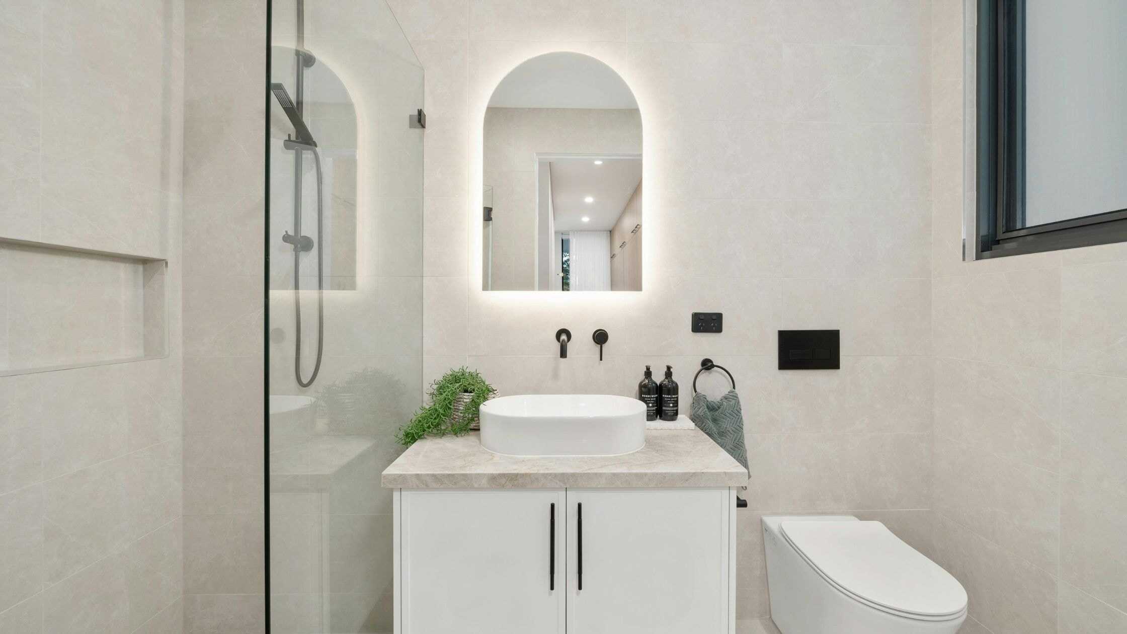 Stylish modern bathroom with minimalist design, white fixtures, and natural light.