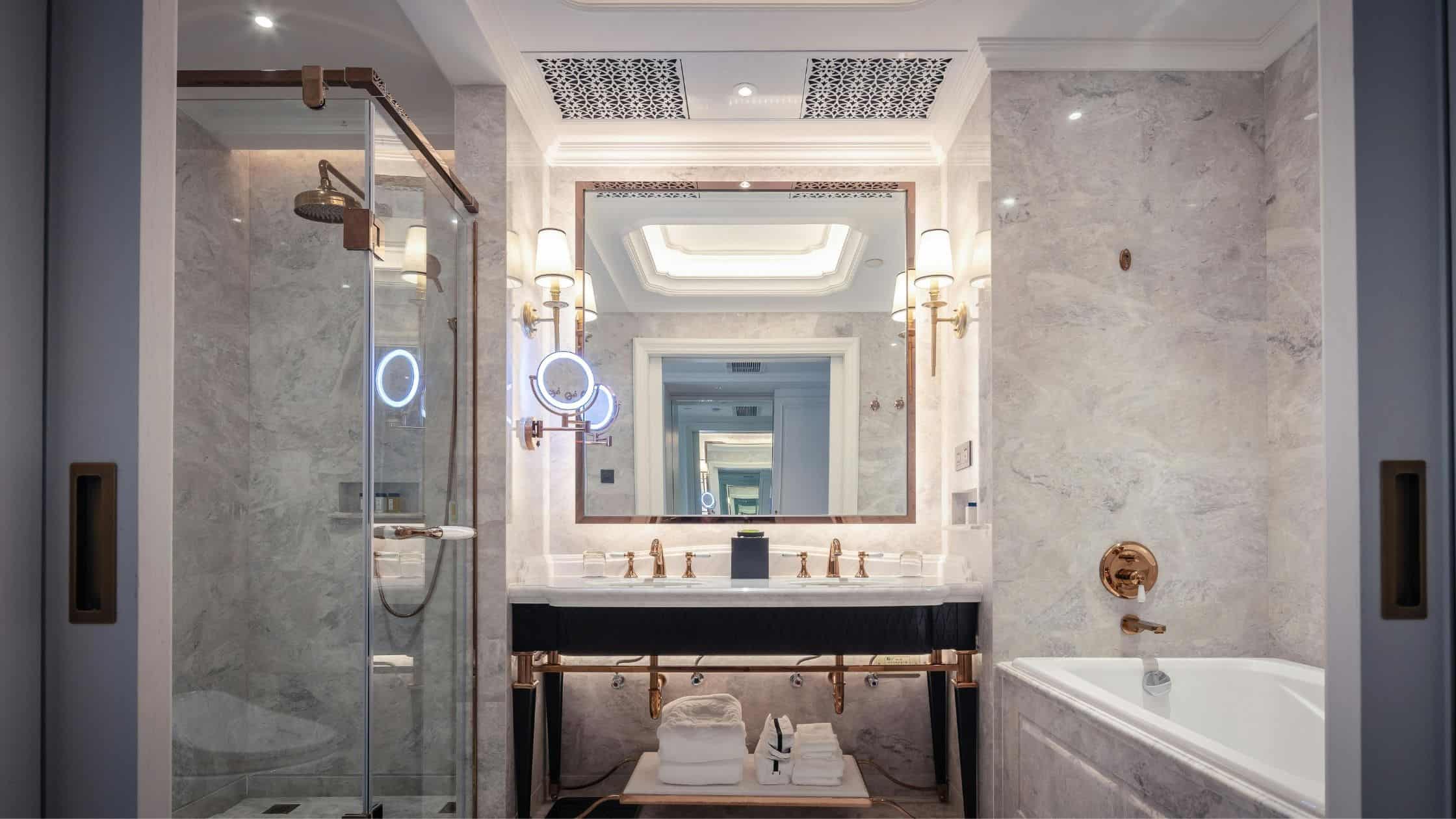 Luxurious bathroom with marble walls and elegant fixtures by Two Aspens Builders.