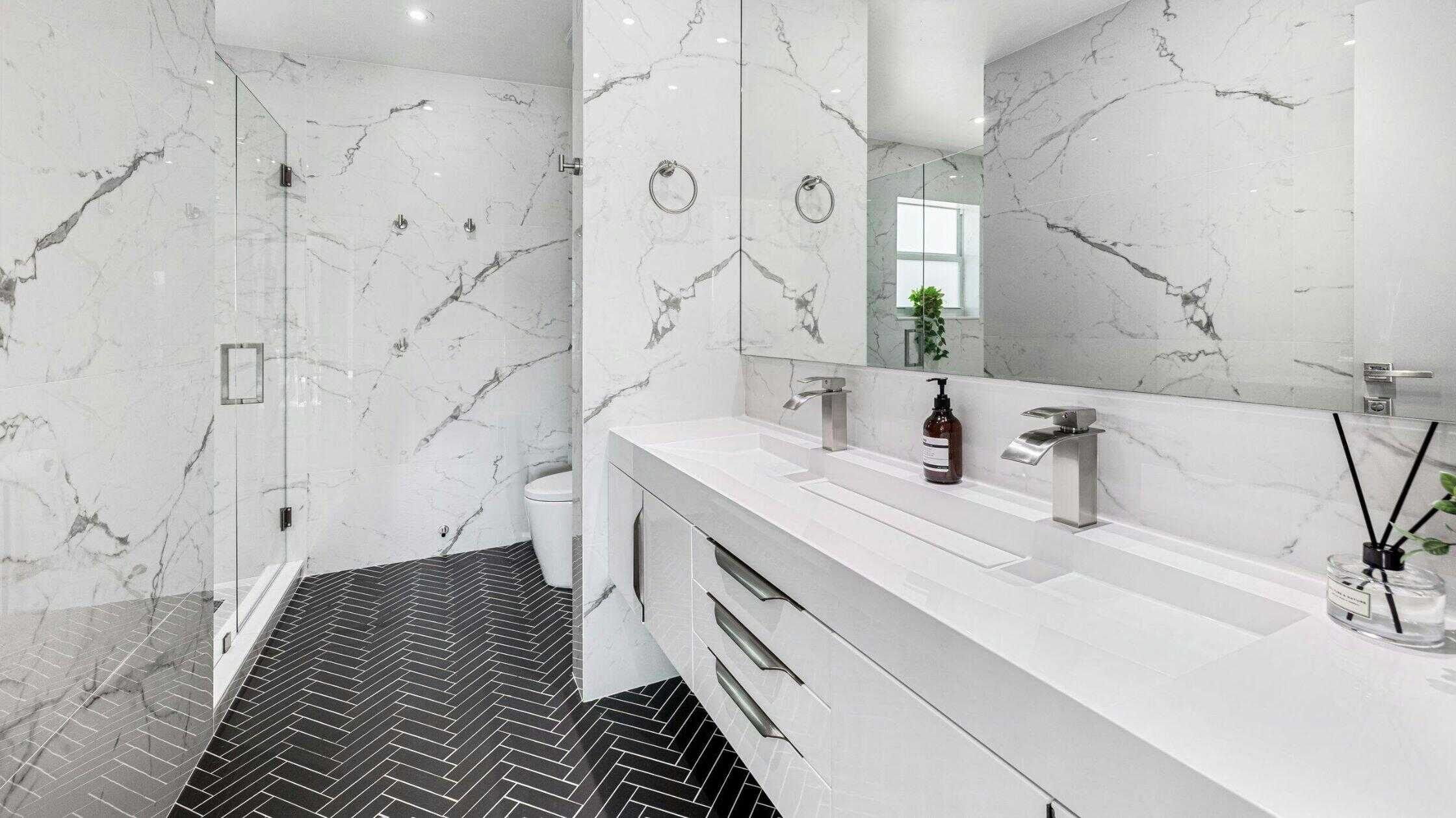 Bright and spacious bathroom with marble walls and sleek fixtures.