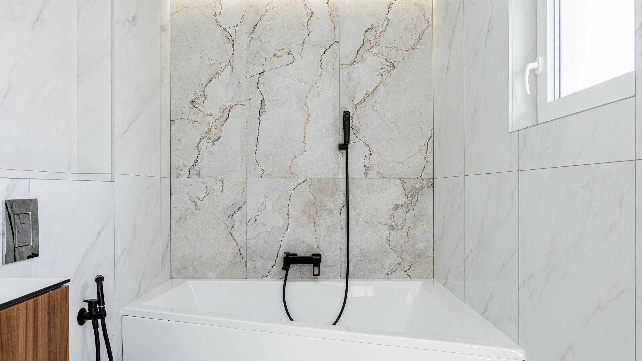 Elegant bathroom with marble walls and a sleek bathtub, showcasing high-quality construction by Two.