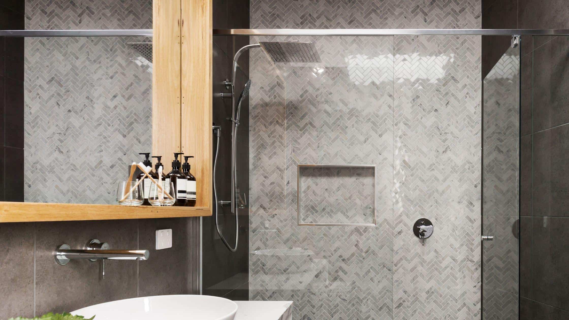 Elegant bathroom with sleek gray tiles and glass shower enclosure. Perfect for contemporary home ren.