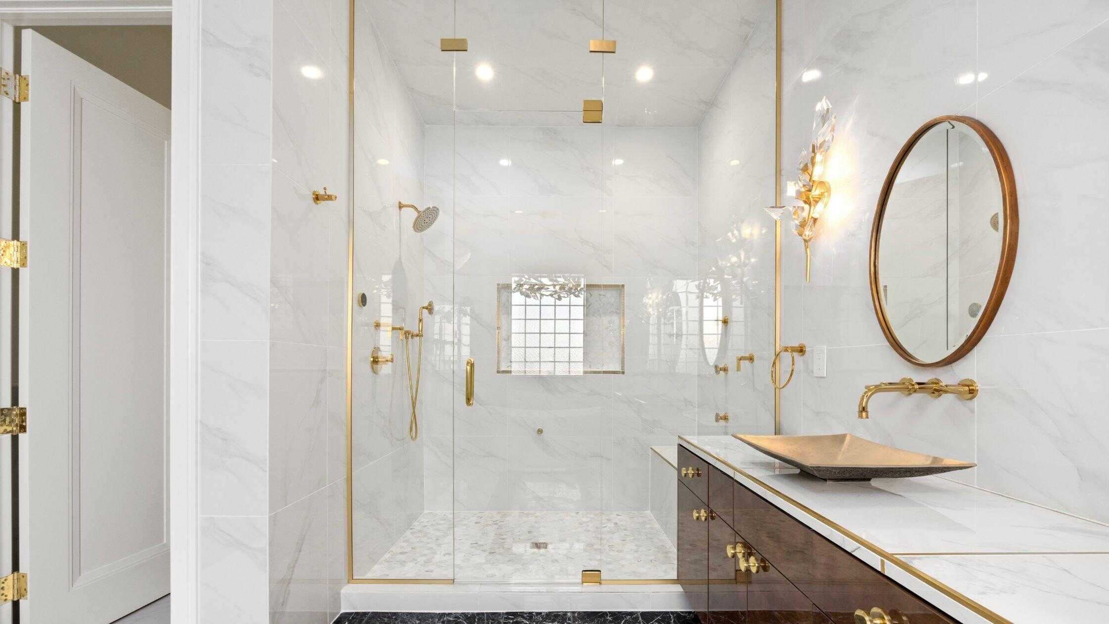 Luxury bathroom with marble walls and gold fixtures.