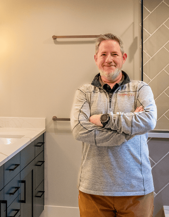 Two Aspens Builder standing confidently in a modern bathroom.