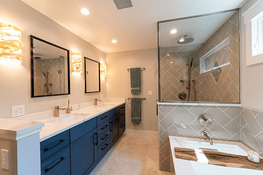 Modern bathroom with dual sinks, large mirrors, and a glass-enclosed shower.